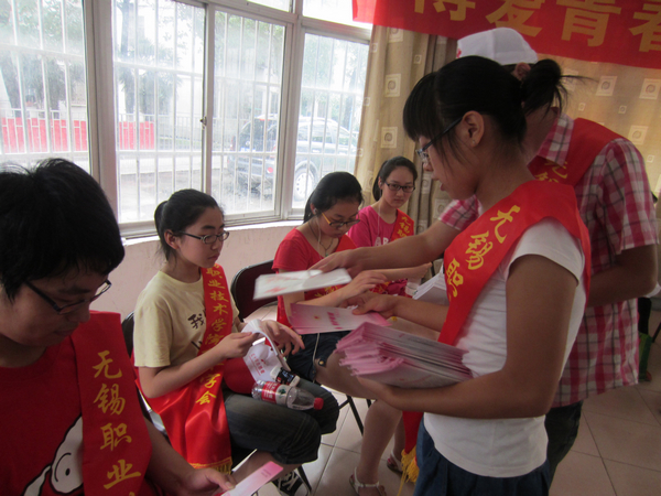 志愿者向社区青少年发放自我救护宣传材料